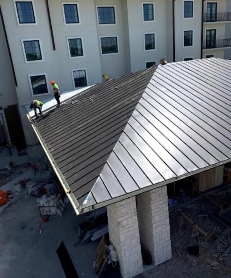 Crew installing standing seam metal roof panels on a commercial project in Union City